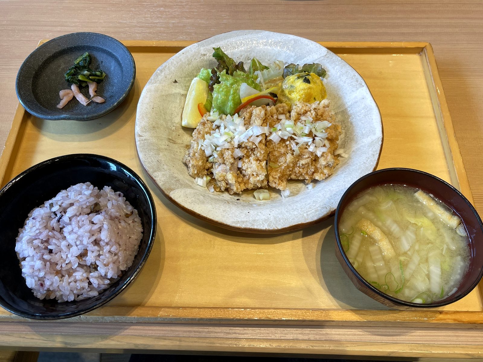揚げ鶏の香味だれ定食の全体。刻みネギをのせた揚げ鶏、サラダ、かぼちゃサラダ、五穀ごはん、白菜とネギの味噌汁