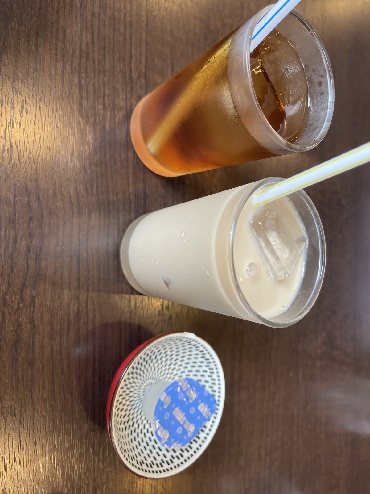 奥がアイスのウーロン茶、手前がミルキーなアイスマサラチャイ。手前にガムシロップの容器が置かれている
