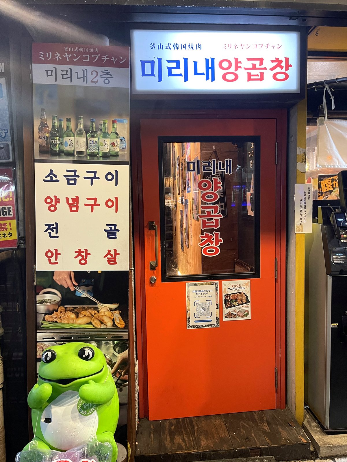 赤い扉の入口。韓国語の看板が光っている