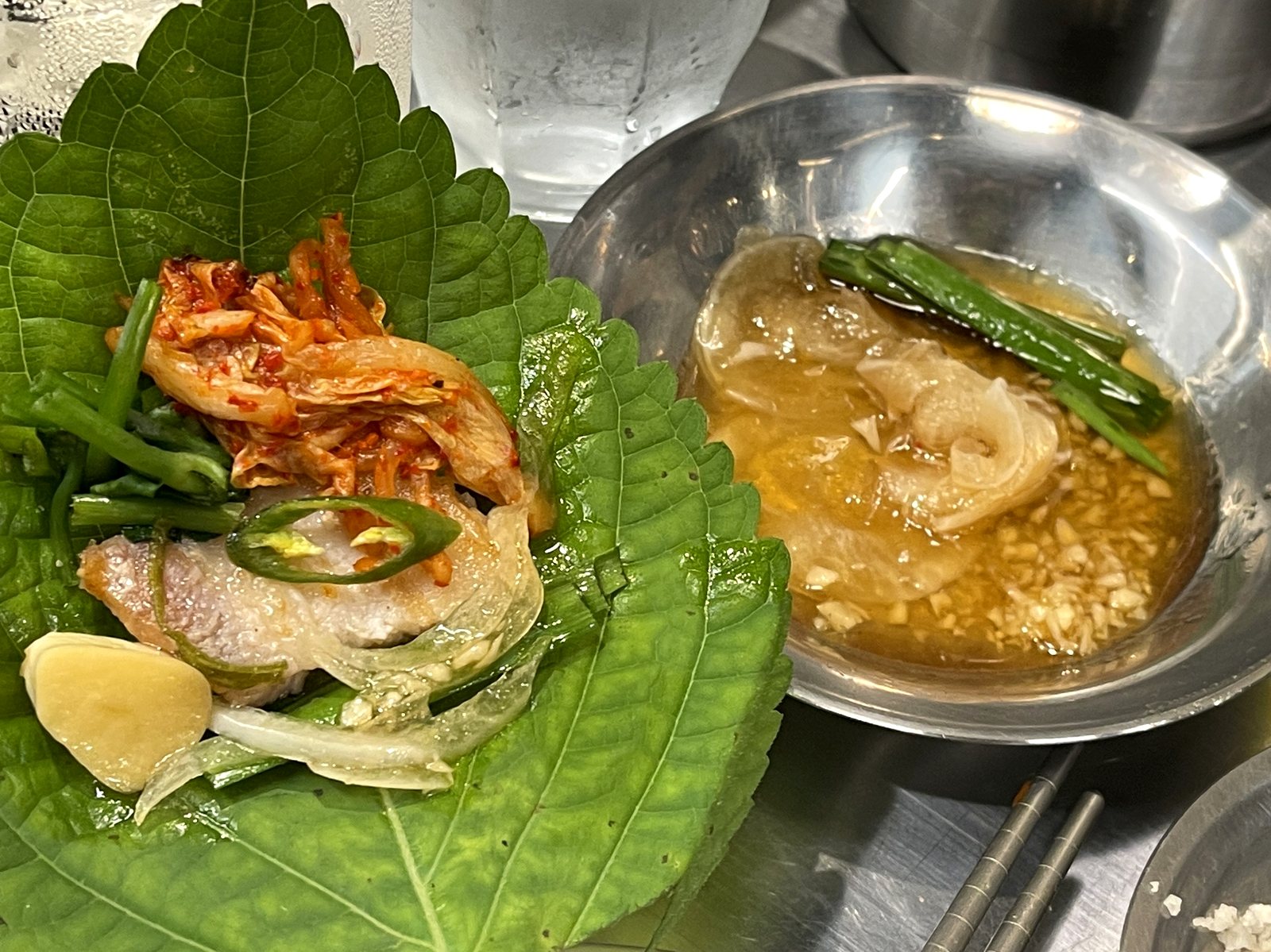 エゴマの葉に乗せた豚肉、キムチ、青唐辛子、玉ねぎのタレ