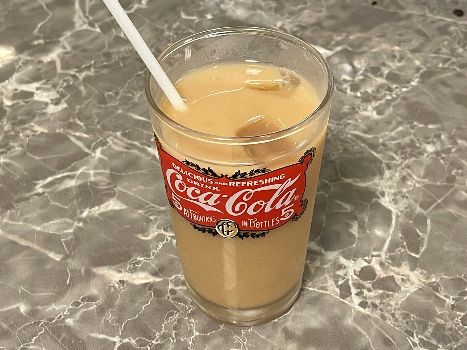 コカ・コーラのグラスに入ったアイスミルクティー