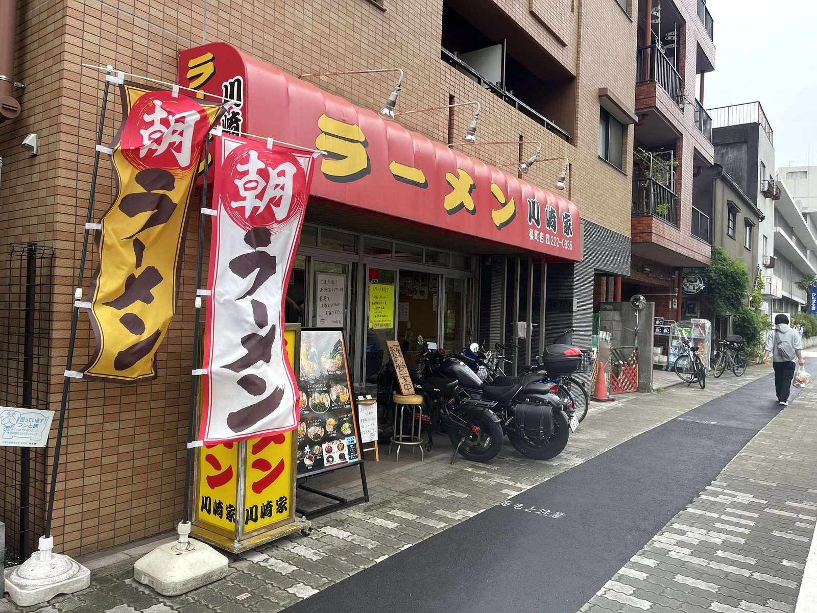 川崎家 榎町店の外観。赤い庇に「ラーメン 川崎家」の看板と「朝ラーメン」ののぼり