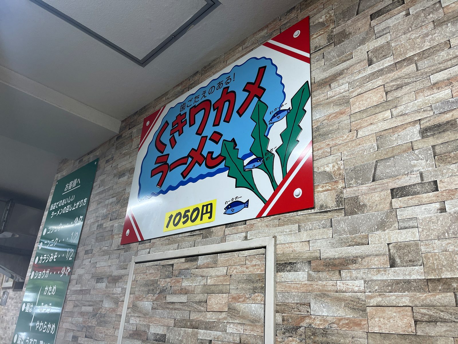「くきワカメラーメン 1050円」と書かれた壁面の看板
