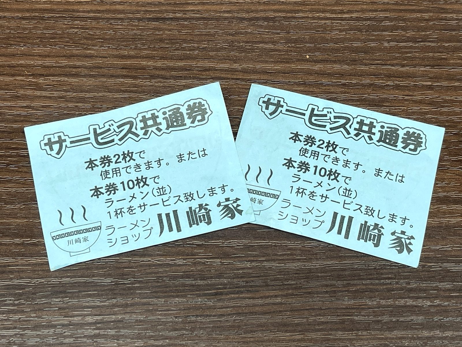 木目のテーブルに置かれた川崎家のサービス共通券2枚