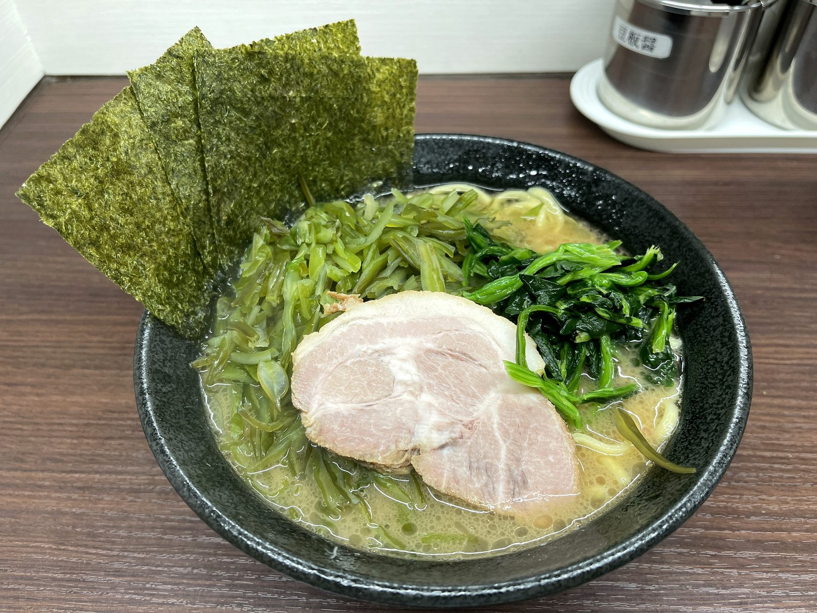 川崎家 榎町店の茎わかめラーメンを俯瞰で撮影。海苔・チャーシュー・茎わかめ・ほうれん草がたっぷり乗っている