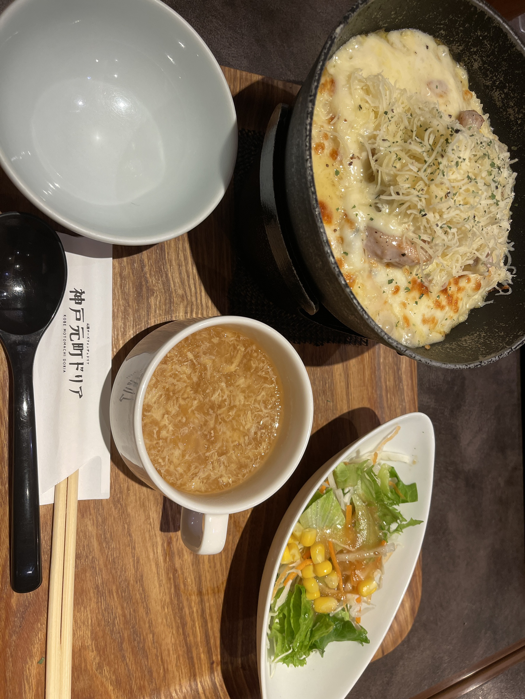 シーフードドリアのアップ。表面いっぱいに大量のシュレッドチーズがのり、こんがりと焼き色がつき、下からごろごろとした具材がのぞいている