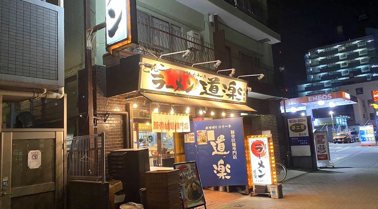 夜のラーメン道楽 川崎店の外観。国道沿いで、隣にはENEOSのガソリンスタンドが見える