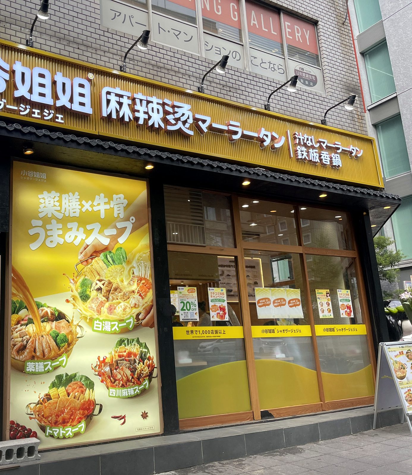 小谷姐姐 川崎店の外観にある「薬膳×牛骨うまみスープ」の大型ポスター。白湯・薬膳・四川麻辣・トマトの4種スープが写真つきで並ぶ