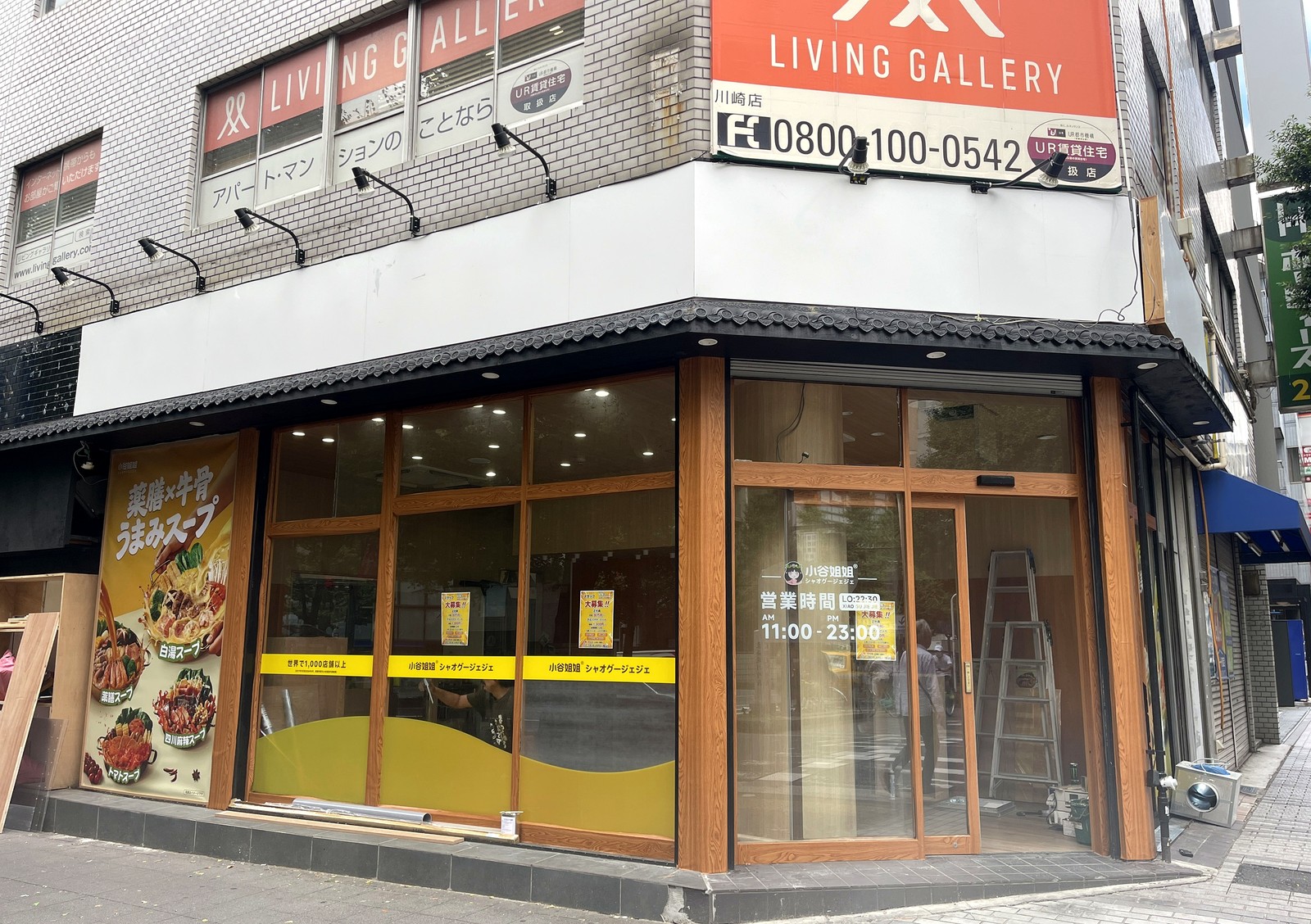 小谷姐姐マーラータン川崎店の外観。薬膳×牛骨うまみスープのポスターと世界で1,000店舗以上の帯、営業時間11:00-23:00の案内