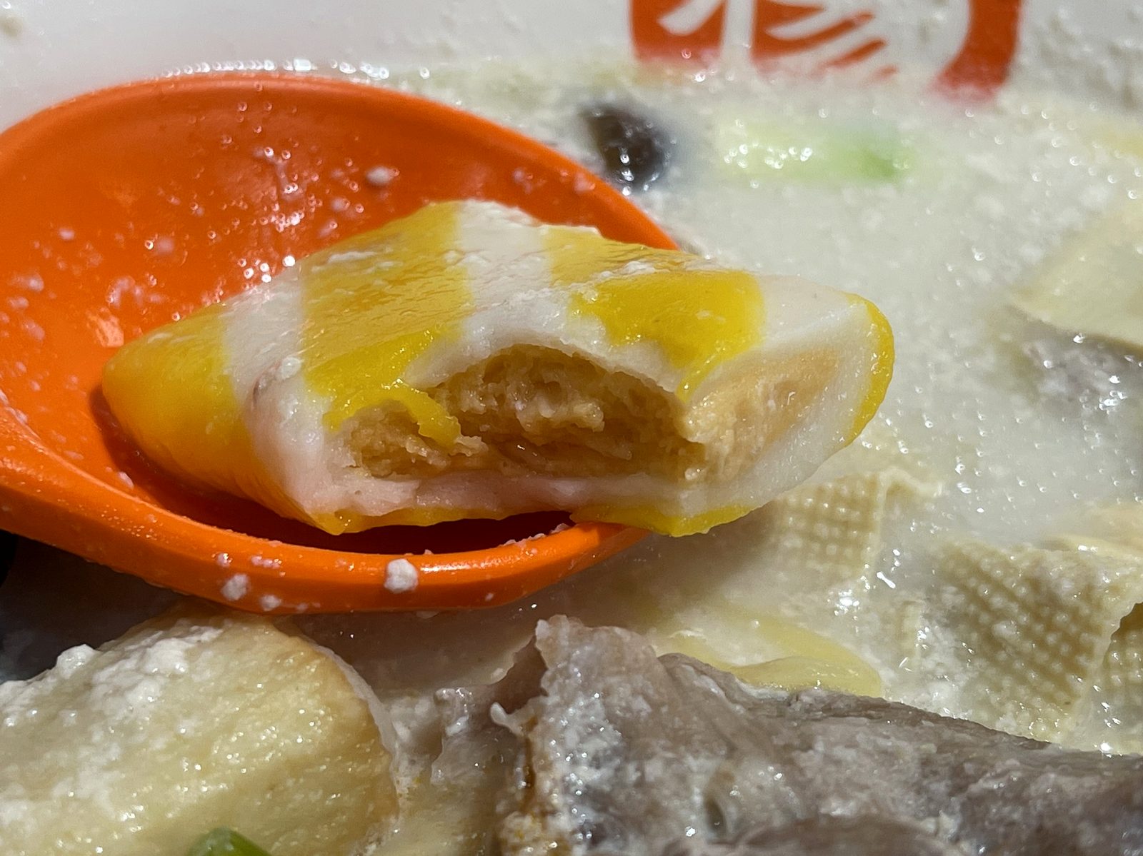 断面を見せたカニカマ。表面はかまぼこ、中に海鮮のすり身が入っている一口