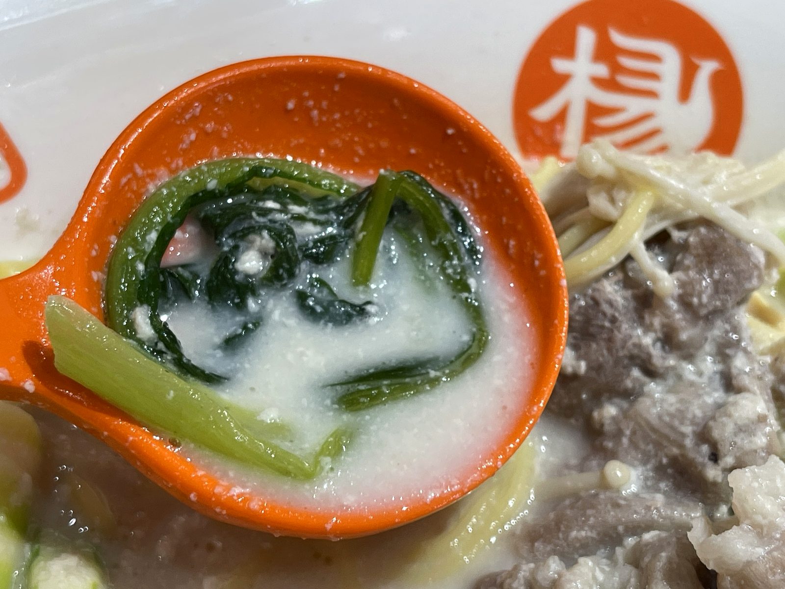 レンゲに乗せた青菜などの葉物野菜のクローズアップ