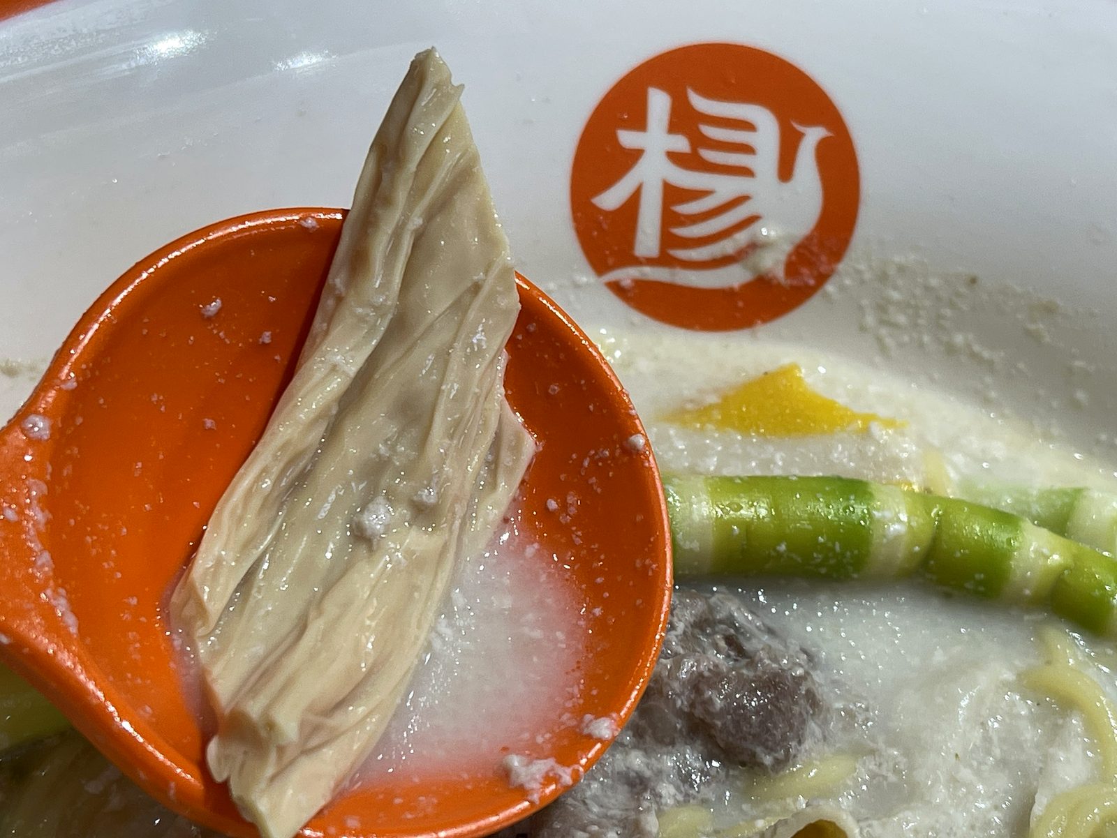 レンゲに乗せた薄くて柔らかい湯葉のクローズアップ