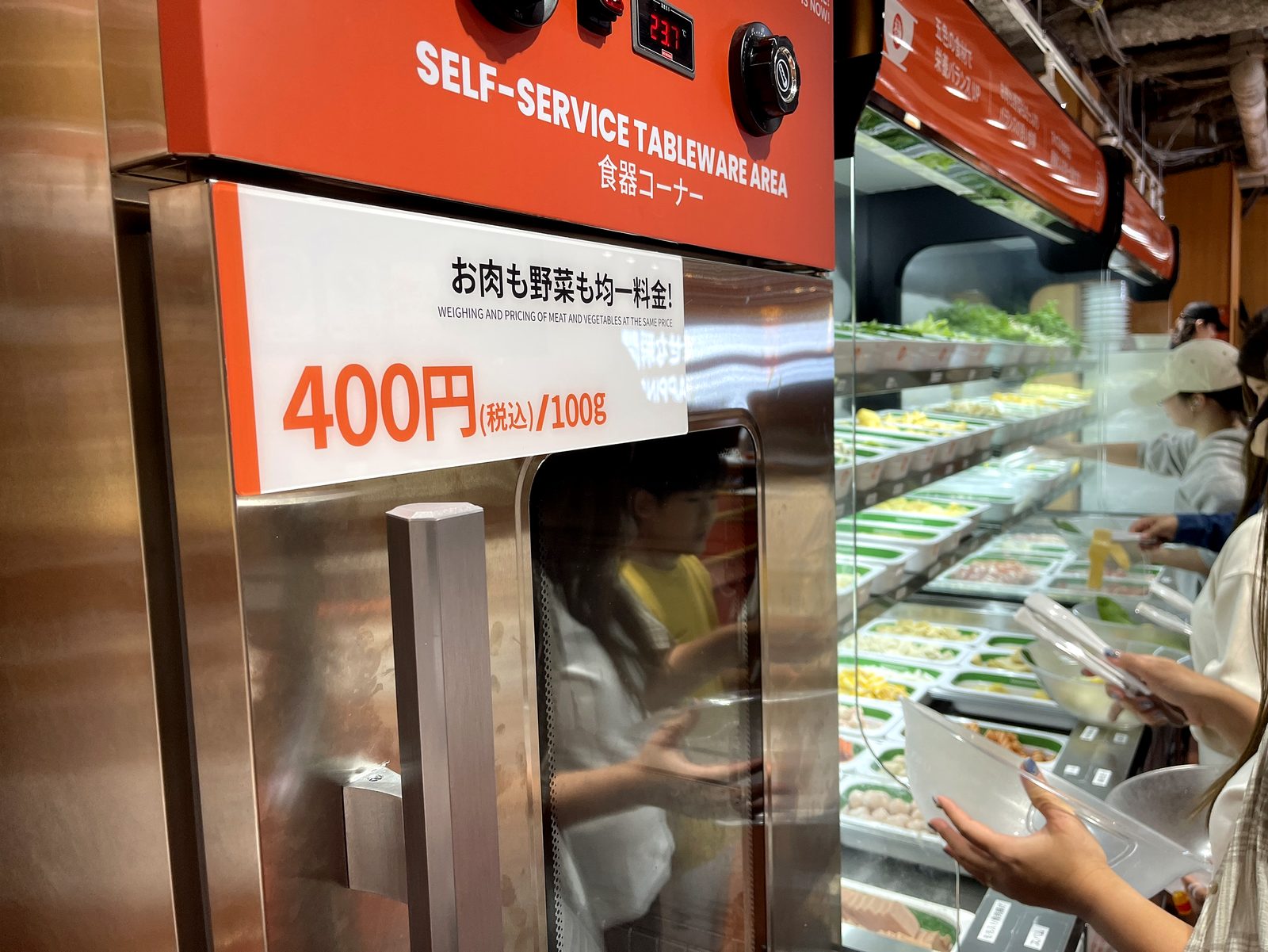 食器コーナーのSELF-SERVICE TABLEWARE AREAの案内。お肉も野菜も均一料金400円税込100gの表示