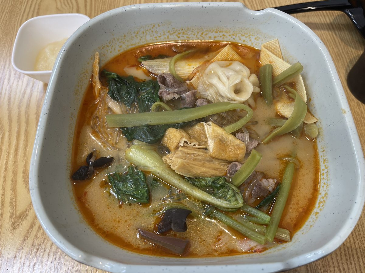 パクチーを混ぜながら食べ進める三寅馬重慶麻辣燙の中辛スープ