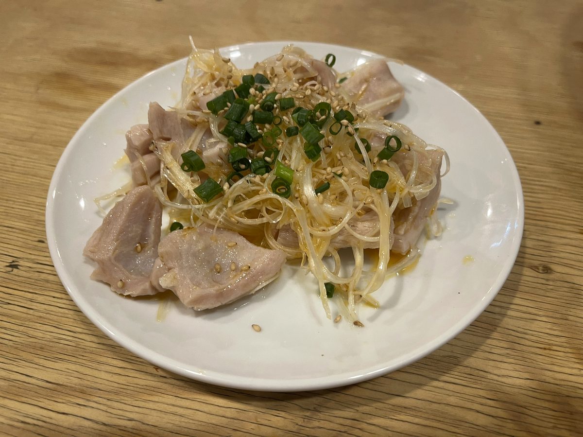 塩で焼き上がったホルモンの一皿、薬味がのっている