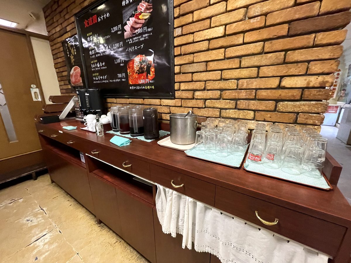 グラスや飲み物のポットが並ぶ食道園のセルフドリンクコーナー