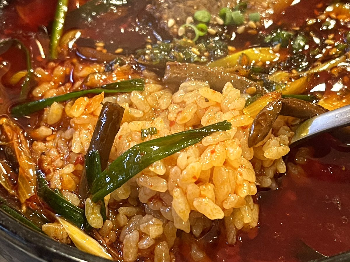 真っ赤なスープを吸って柔らかくなった食道園カルビクッパのご飯のアップ
