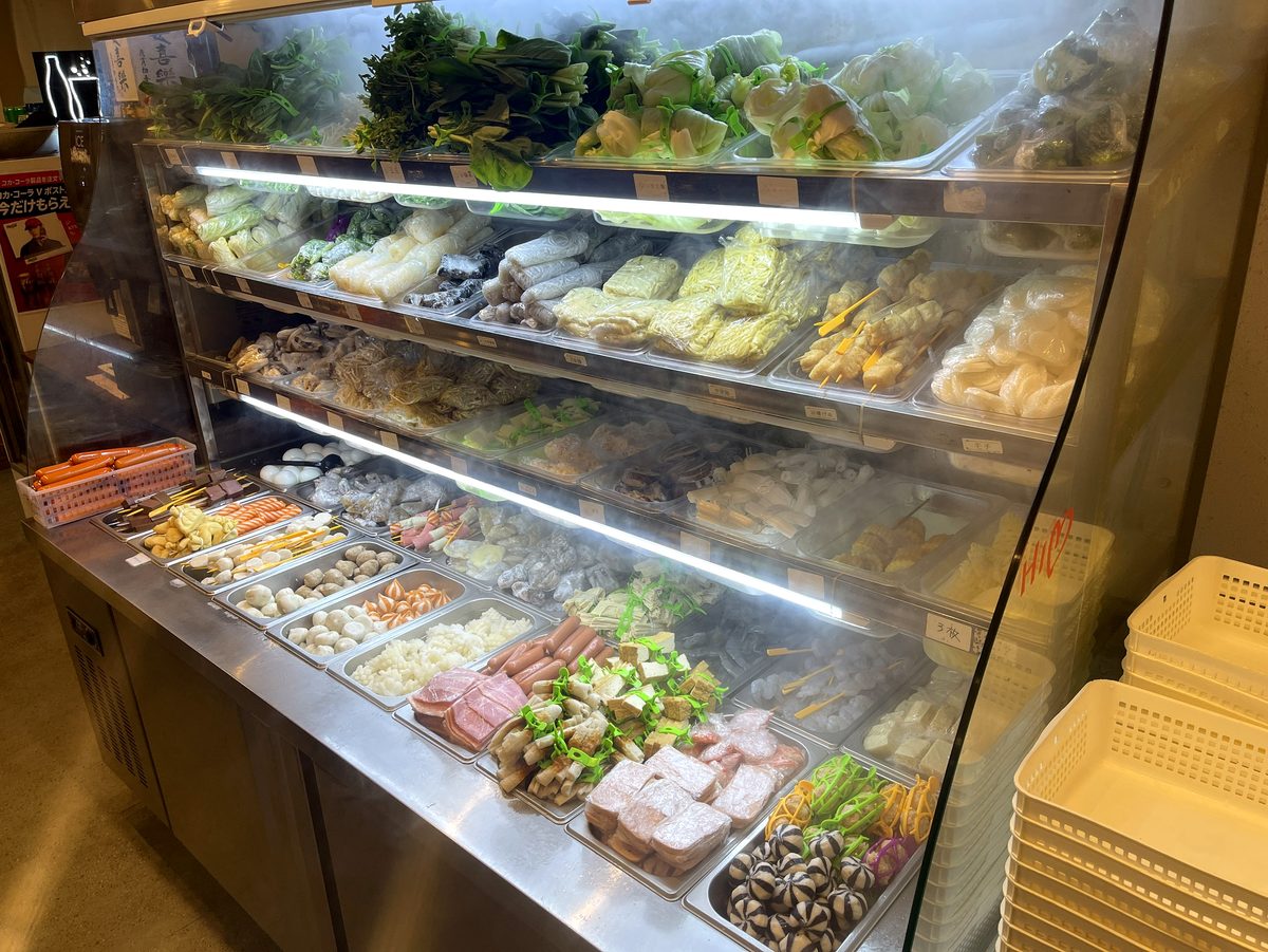 葉物野菜やきのこ練り物など具材がずらりと並ぶ冷蔵ショーケース