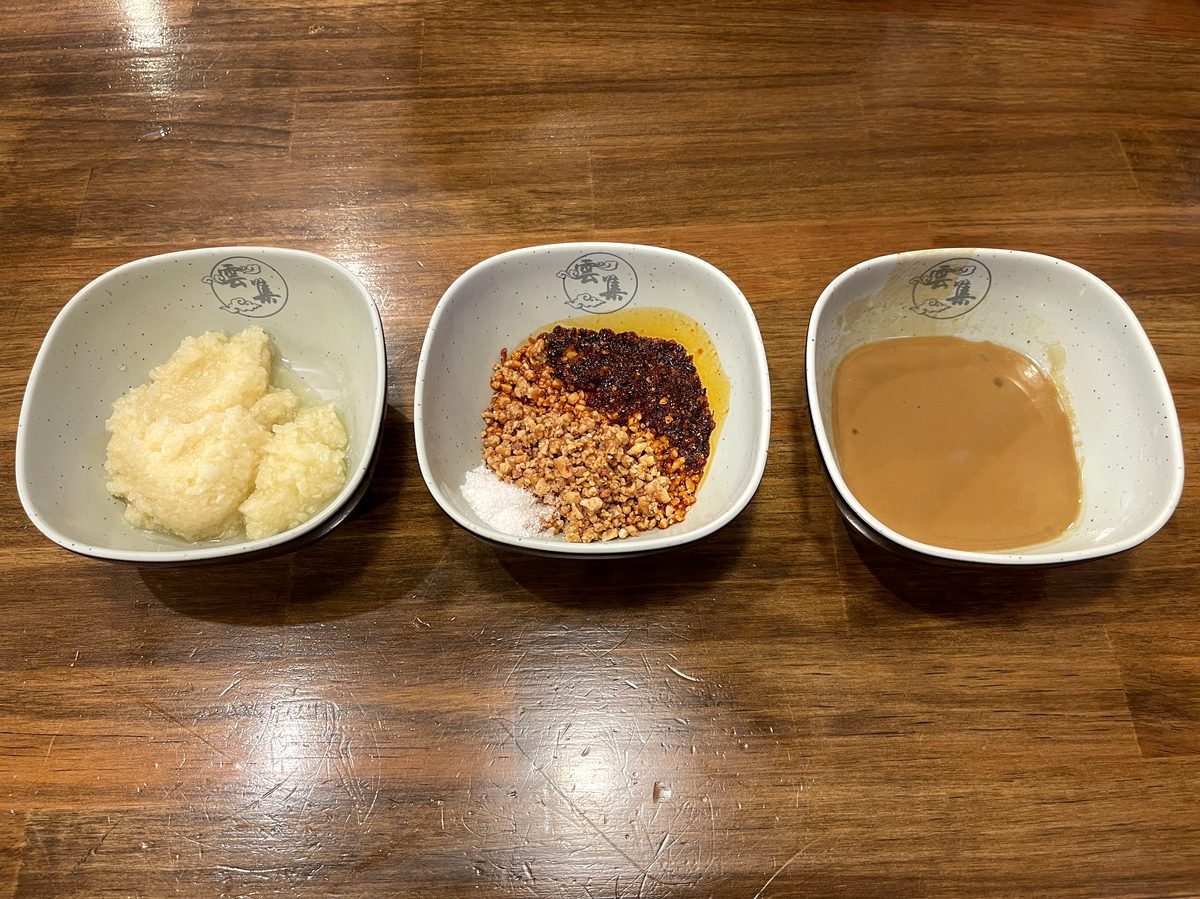 にんにくとラー油ピーナッツごまダレを取り分けた3つの小皿