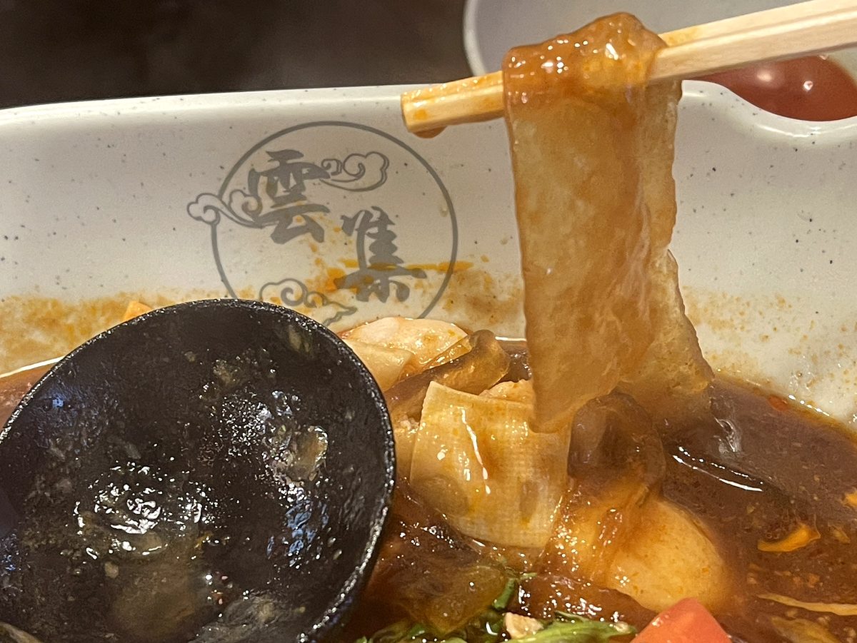 箸で持ち上げた板春雨がスープと絡む様子