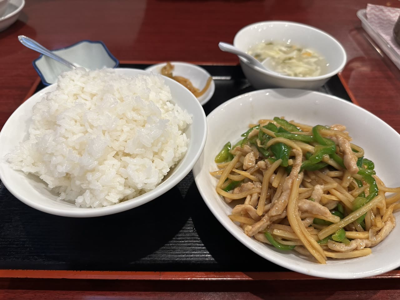 青椒肉絲のアップと大盛りの白米。細切りの豚肉、ピーマン、たけのこ